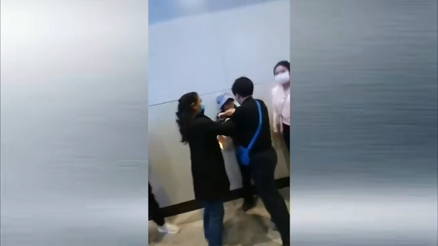 北京一名女访民被截访女子凶狠地揪住脖领不放.png