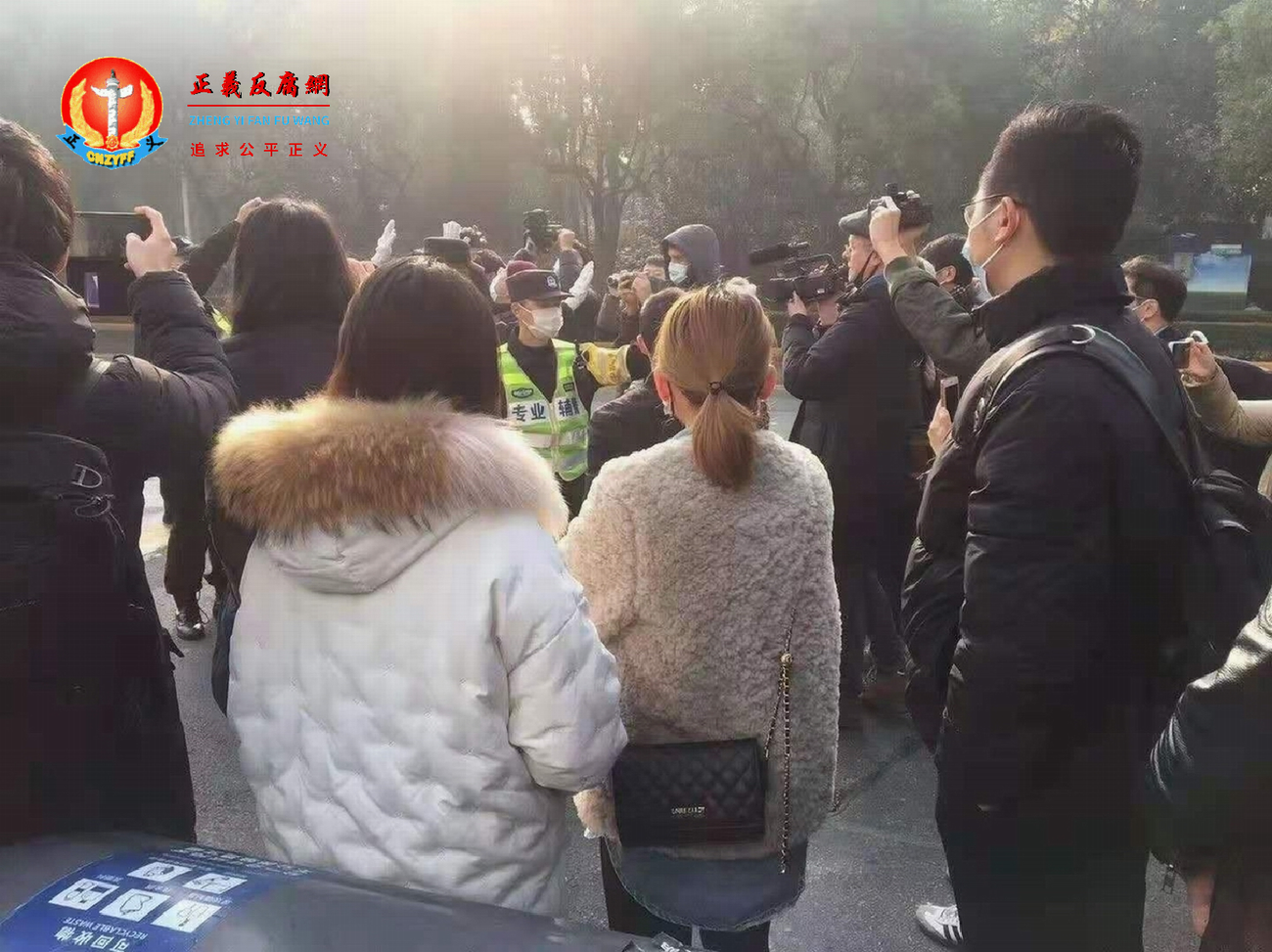 维权律师、公民记者张展案在上海市浦东新区法院开庭，遭重判四年。图为法庭外警察驱赶声援者。.png