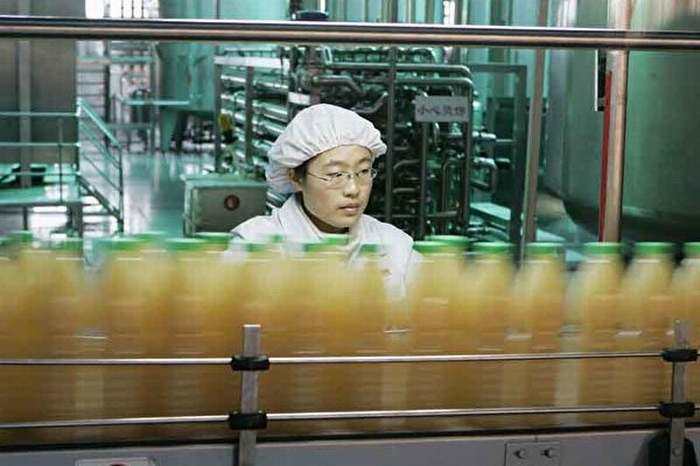 一位女工在汇源果汁厂流水线上工作.jpg