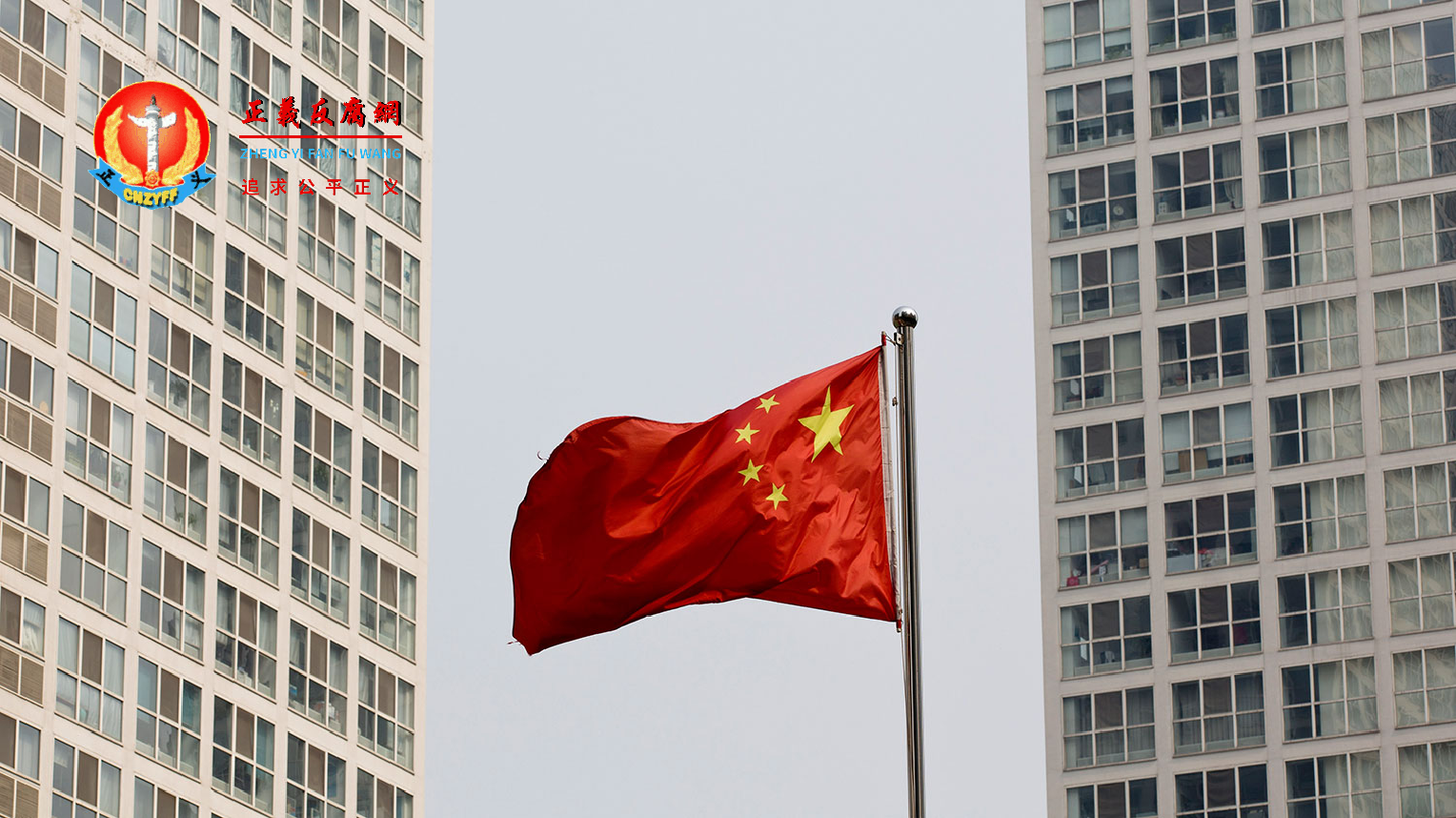 北京的一座高层住宅和办公大楼之间随风飘扬的国旗。.png
