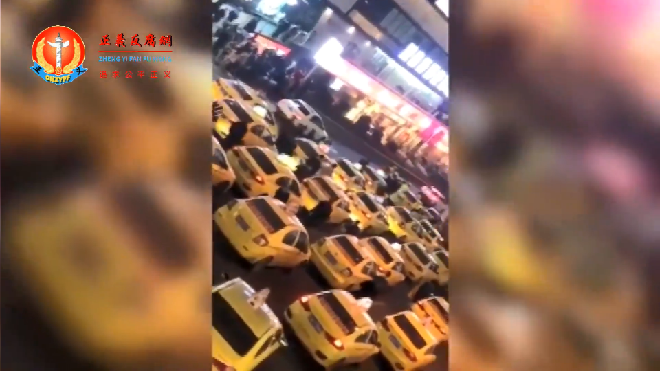 重庆市区浩浩荡荡的缓慢行驶着，大批出租车亮着车灯，暂停在城区马路中央.png