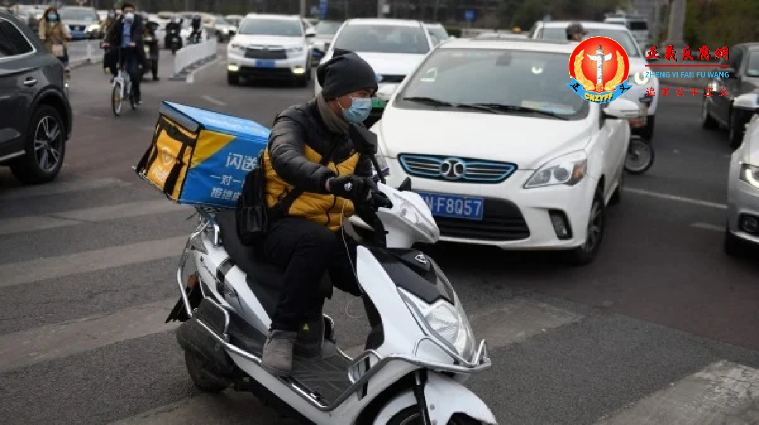 图为2020年3月24日，一名外送员在北京的一个十字路口驶过。.png