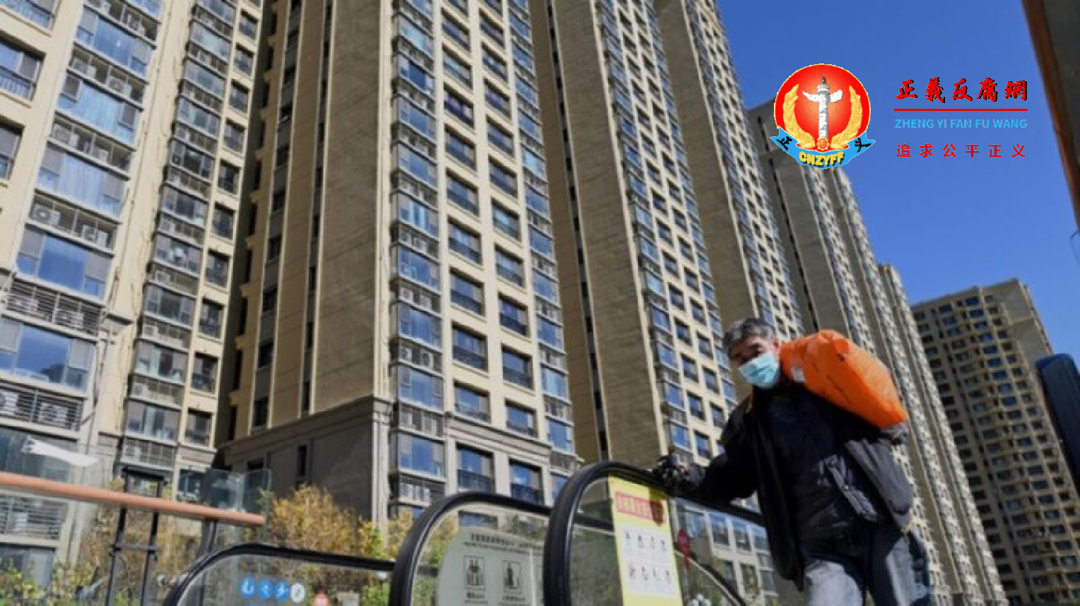 2021 年 10 月 21 日，北京市内一名男子背着行李从恒大集团开发的住宅楼前经过。.png
