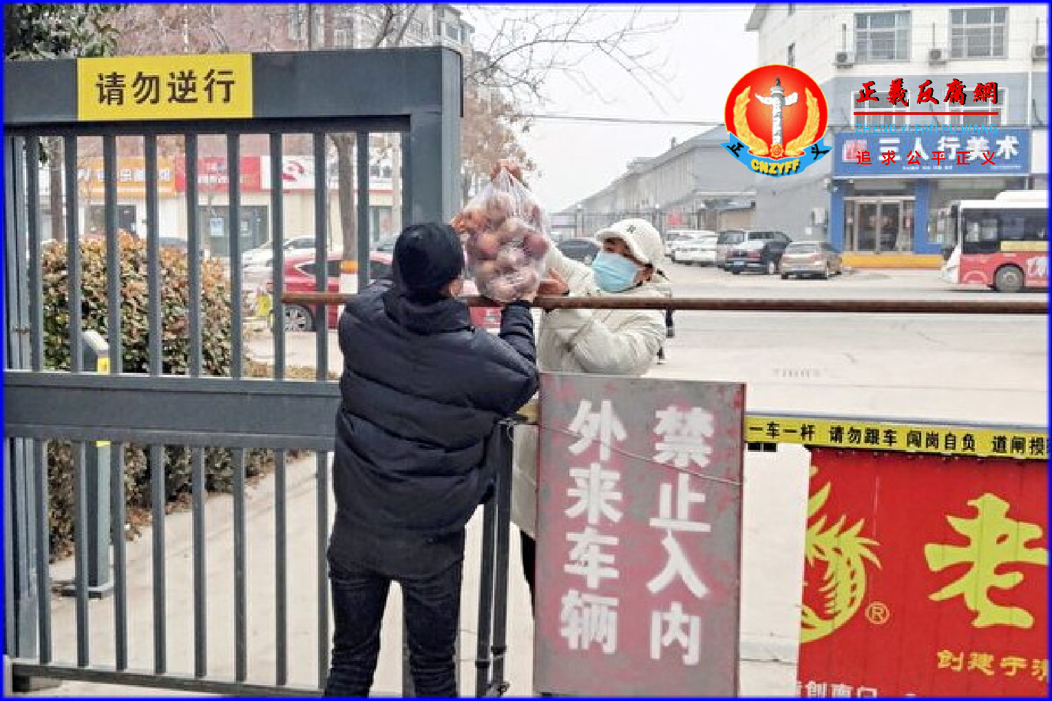 2022年1月12日，Covid-19（病毒、官状病毒）新一轮疫情爆发之际，河南省安阳市一名被隔离的居民正在小区门口处领取食物。.png